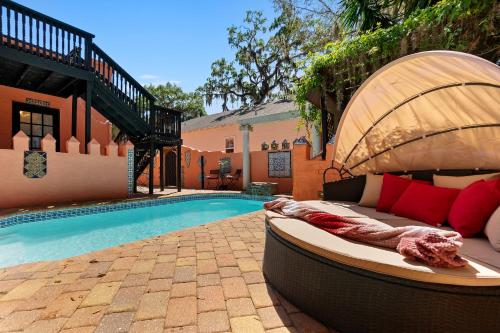 a swimming pool with a bed next to a house at The Gaudi House- Pool Minutes to DNTN and Beach in St. Augustine