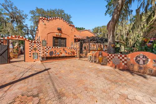 an orange brick house with a gate and a tree at The Gaudi House- Pool Minutes to DNTN and Beach in St. Augustine