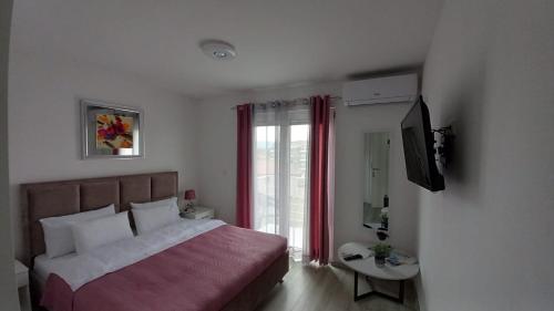 a bedroom with a large bed and a television at Lago d'argento sobe in Veliko Gradište