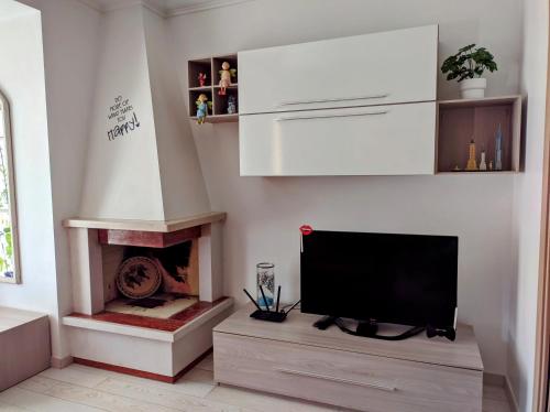 sala de estar con TV y chimenea en La casetta gialla, en Roma