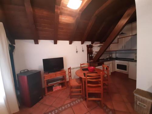 eine Küche und ein Esszimmer mit einem Tisch und einem TV in der Unterkunft Casa Graciano II in Ochagavía