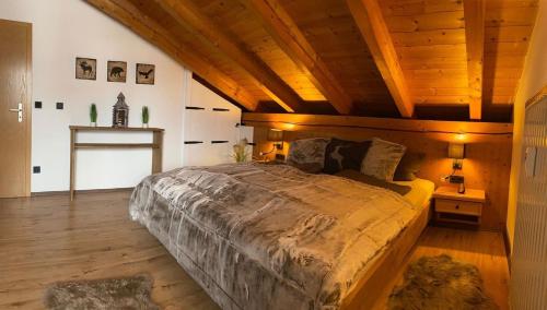 a bedroom with a large bed with a wooden ceiling at Edelweiss -229- in Mittenwald