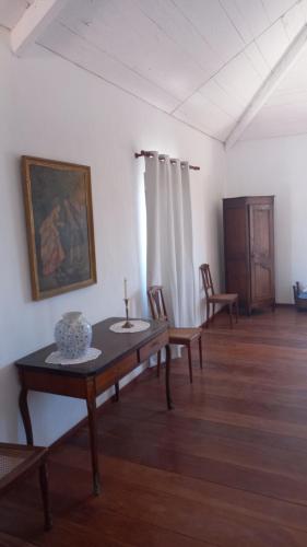 a room with a table and chairs and a painting at Casa Azul in Mindelo