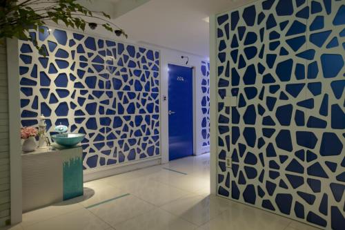 a hallway with a blue and white patterned wall at Max Motel - Sasang in Busan