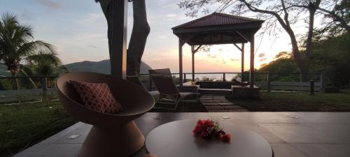 a room with a table and a gazebo with flowers on it at Hotel - Résidence Habitation Grande Anse in Deshaies