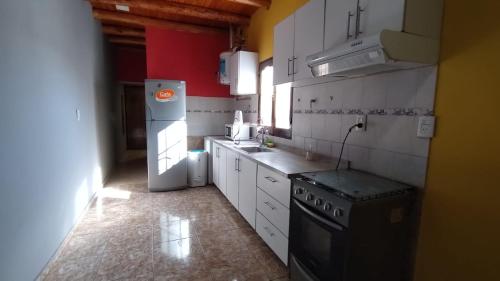 a kitchen with a stove and a refrigerator at Alquiler por día/semana in Ciudad Lujan de Cuyo