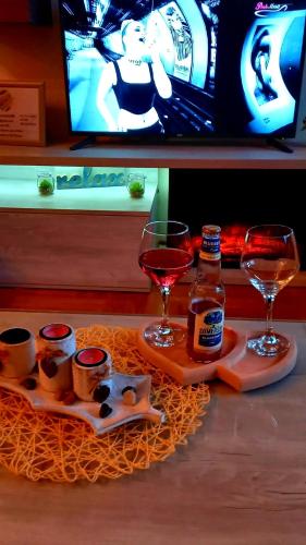 a table with two glasses and a bottle of wine at Sweet Dreams SPA in Zlatibor