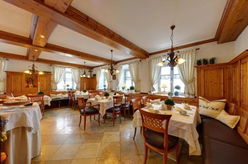 a restaurant with tables and chairs in a room at Boutique Hotel POST ANDECHS in Andechs