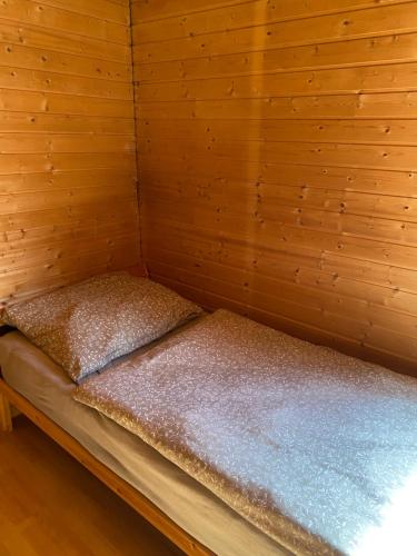 uma pequena cama num quarto com paredes de madeira em Chata u certovych hlav 3 em Želízy