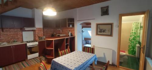 eine Küche mit einem Tisch und einem Tisch sowie ein Esszimmer in der Unterkunft Casa de vacanta - Vendeghaz in Borsec
