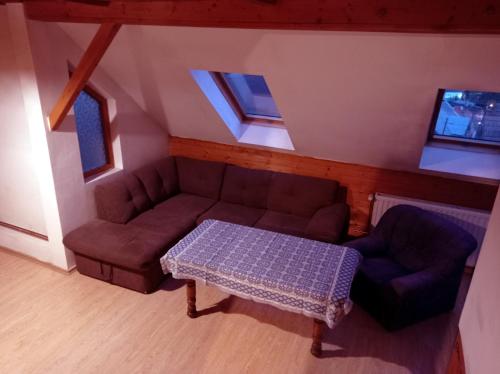 sala de estar con sofá y mesa en Casa de vacanta - Vendeghaz en Borsec