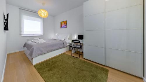 a white bedroom with a bed and a desk at Good Vibes in Zagreb