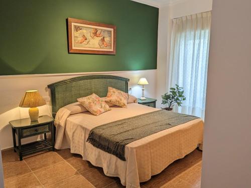 a bedroom with a bed and a green wall at Terraza con vistas al mar Parking privado 120 mts, junto a la playa in Cullera
