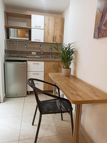 a kitchen with a wooden table and a chair at Laureles Guest House LGH Hotel in Medellín