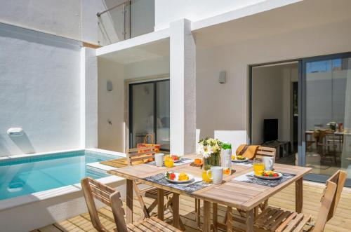 a dining table and chairs next to a swimming pool at Bela Vista in Cascais
