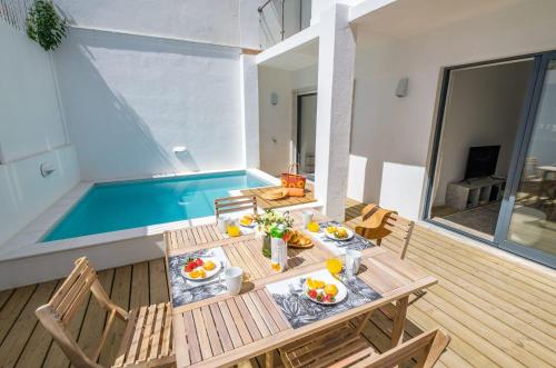 a table with food on it next to a swimming pool at Bela Vista in Cascais