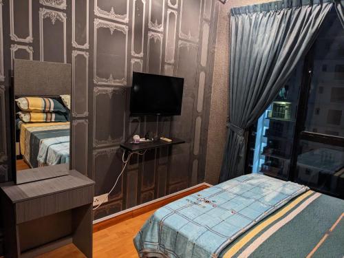 een slaapkamer met een bed en een tv aan de muur bij D'Zayn Serviced Apartment at The Platino Johor Bahru in Johor Bahru