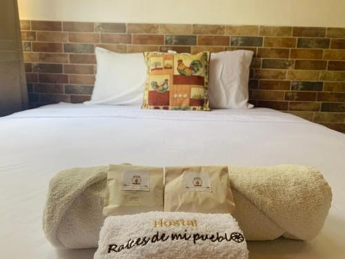 Una cama con dos toallas encima. en Hostal Raíces de mi Pueblo en Suchitoto