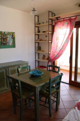 - une salle à manger avec une table et des chaises en bois dans l'établissement Charming flat in Santa Teresa Gallura, à Santa Teresa Gallura