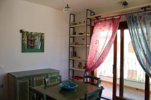 una sala da pranzo con tavolo e finestra di Charming flat in Santa Teresa Gallura a Santa Teresa di Gallura