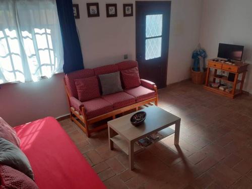 a living room with a red couch and a table at Casa da Açoteia, Fuseta in Fuzeta