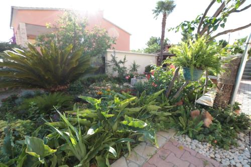 a garden in front of a house with plants at Apartments Villa Flamingo in Makarska