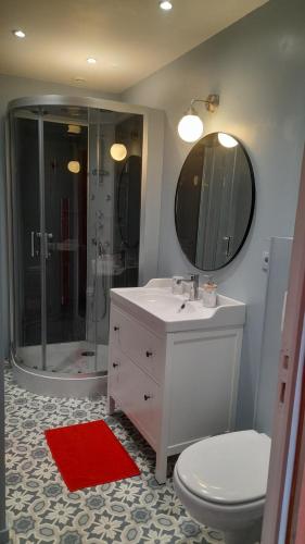 a bathroom with a toilet and a sink and a shower at Abrigermaine in Arromanches-les-Bains