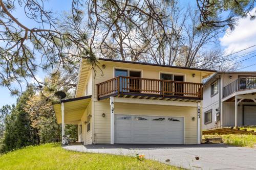 a yellow house with a balcony and a garage at Big Creek Hideaway in Groveland