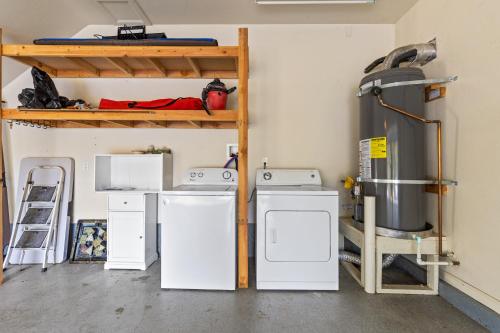 a laundry room with three washers and a shelf at Big Creek Hideaway in Groveland