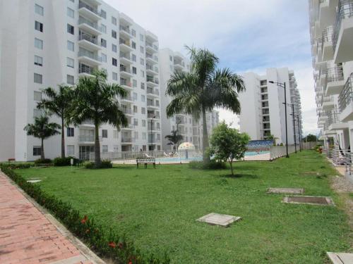 a park in front of a building with palm trees at Apartamento agradable para disfrute y relajación in Girardot