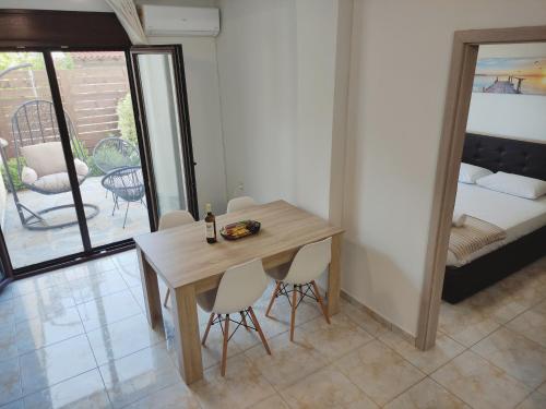 a dining room with a table and chairs and a bed at Sunny Siviri in Siviri
