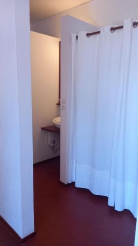 a room with two white curtains and a table at Casa Azul in Mindelo