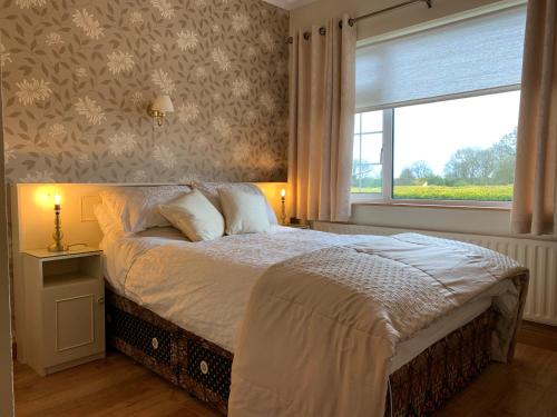 sypialnia z dużym łóżkiem i oknem w obiekcie Bridgeview B&B w mieście Ennis