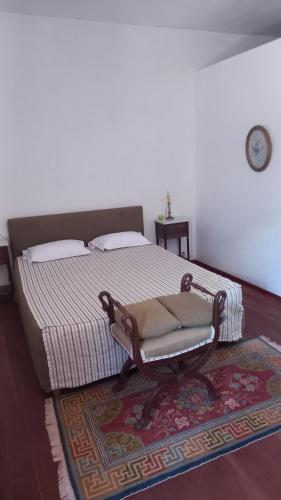 a bedroom with a bed and a chair on a rug at Casa Azul in Mindelo