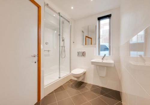 a bathroom with a toilet and a shower and a sink at Turnstones in Southwold