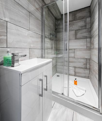 a bathroom with a shower and a sink and a tub at Aldgate Flats in London