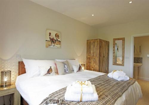 a bedroom with a large white bed with towels on it at Pheasant in Saint James