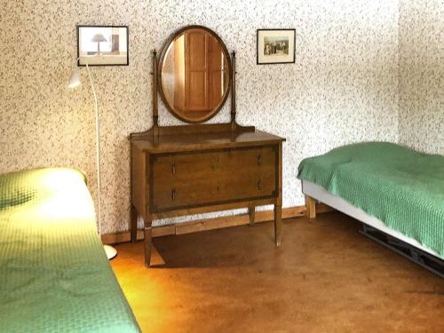 Holiday home RÄTTVIK في راتفيك: غرفة نوم مع مرآة وسرير وخزانة