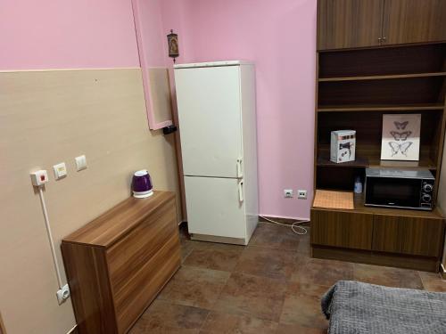 a kitchen with a white refrigerator and a microwave at Like Home Guest Rooms in Sofia