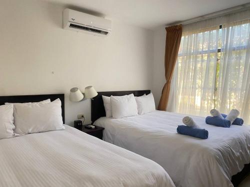 two beds with teddy bears on them in a bedroom at Nacazcol - Playas del Coco in Coco