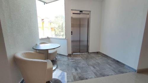 a bathroom with a toilet and a table and a glass door at Hotel Prvan in Vrgorac