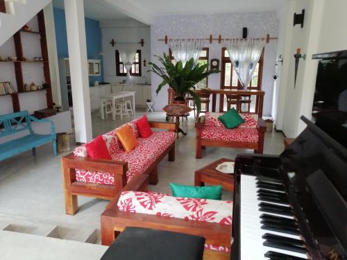 uma sala de estar com cadeiras e um piano em Sithila Villa em Mount Lavinia