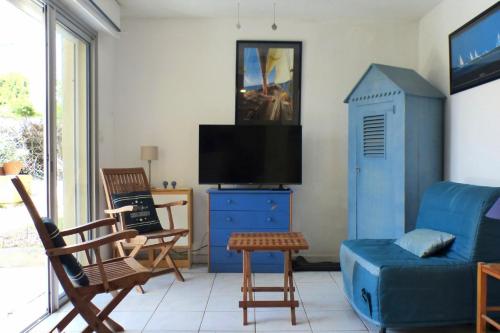 ein Wohnzimmer mit einem blauen Sofa und einem TV in der Unterkunft Nice 33 m apartment with garden and terrace in Six-Fours-les-Plages
