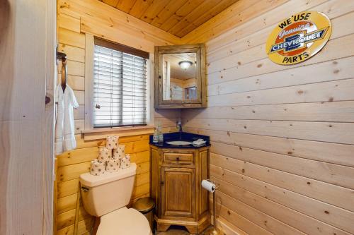 a bathroom with a toilet and a wooden wall at North Fork Cabin in Cle Elum