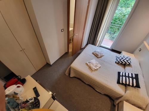 ブレンゾーネにあるHotel Garni Rosmariのベッドと窓が備わる小さな客室です。