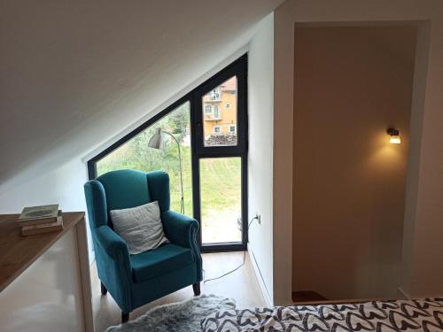Gornja Toplica的住宿－Bruka house Vrujci，蓝色椅子坐在窗户的房间