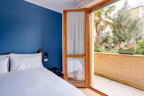 a bedroom with a bed and a large window at B&B Le Palme in Grottammare