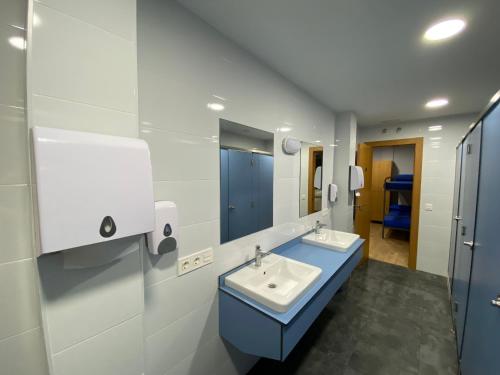 a bathroom with two sinks and a mirror at Albergue El Camino de Santovenia in Santovenia de Oca