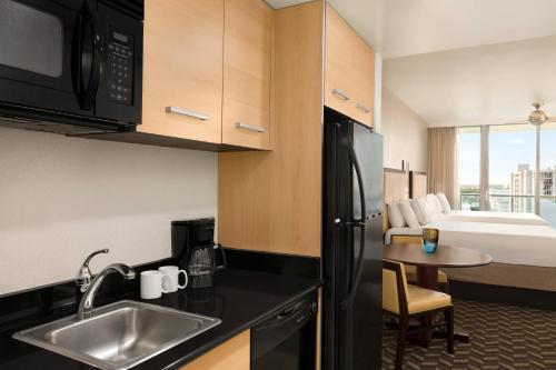 uma cozinha com um lavatório e um quarto com uma cama em Residence Inn by Marriott Fort Lauderdale Intracoastal em Fort Lauderdale