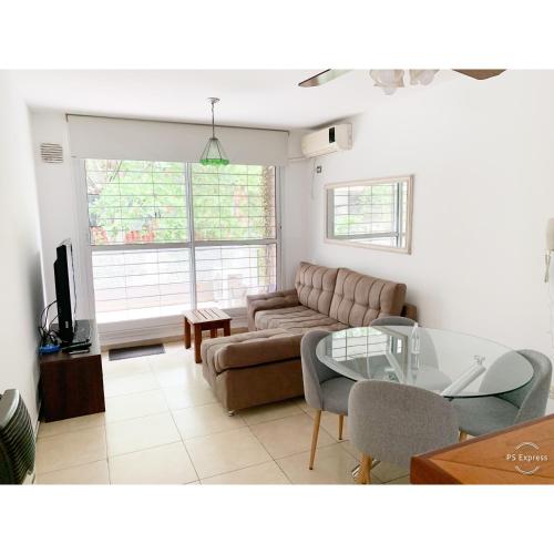 a living room with a couch and a glass table at Departamento amplio, cochera incluida, zona centro in Rosario